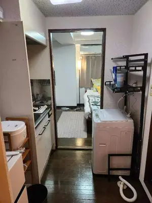 a room with a kitchen with a mirror and a room at \u5409\u5c4b-\u65b0\u5bbf in Tokyo