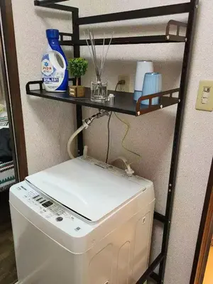 a washing machine in a room with a shelf at \u5409\u5c4b-\u65b0\u5bbf in Tokyo
