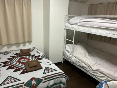 two bunk beds in a room with a bed and a pillow at \u5409\u5c4b-\u65b0\u5bbf in Tokyo