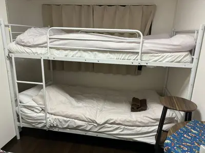 two bunk beds in a room with a table and a chair at \u5409\u5c4b-\u65b0\u5bbf in Tokyo