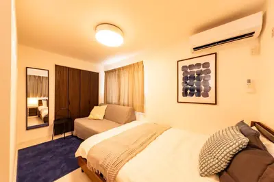 a bedroom with a bed and a couch and a mirror at Enjoy Tokyo Hotel in Tokyo
