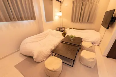 a small room with two beds and a table at Enjoy Tokyo Hotel in Tokyo