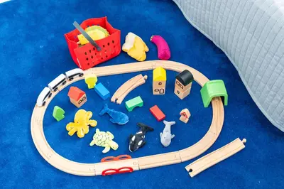 a wooden toy train with toys on a blue carpet at Enjoy Tokyo Hotel in Tokyo