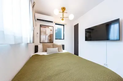 a bedroom with a bed and a flat screen tv at Enjoy Tokyo Hotel in Tokyo
