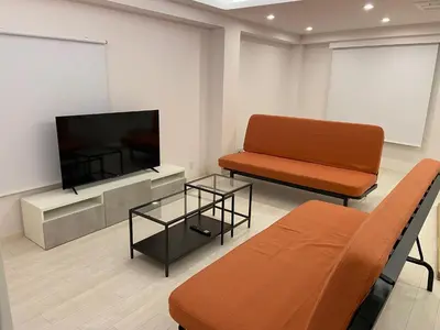 a living room with a couch and a flat screen tv at MY House YANESEN Tokyo2 in Tokyo