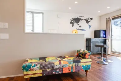 a living room with a couch and a map on the wall at FRt\u5e73\u4e95\u6238\u5efa\u3066 in Tokyo