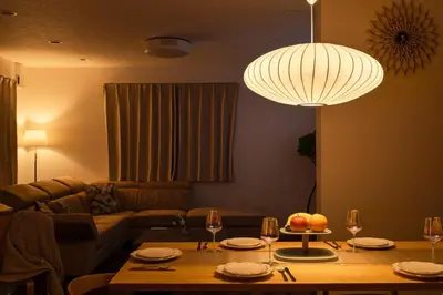 a living room with a table and a chandelier at FRt\u5e73\u4e95\u6238\u5efa\u3066 in Tokyo