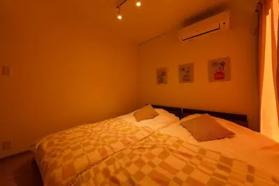 a bedroom with a bed with a yellow blanket at FRt\u5e73\u4e95\u6238\u5efa\u3066 in Tokyo