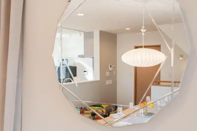 a mirror reflecting a room with a table and a light at FRt\u5e73\u4e95\u6238\u5efa\u3066 in Tokyo