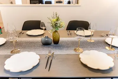 a table with white plates and wine glasses on it at STs\u7b39\u585a2\u4e01\u76ee in Tokyo