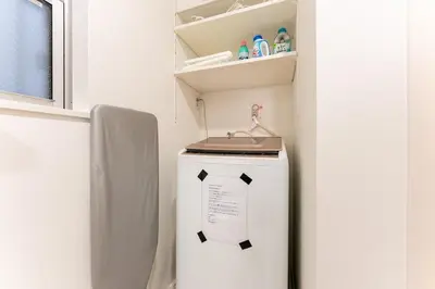 a small refrigerator in a kitchen with a shelf at STs\u7b39\u585a2\u4e01\u76ee in Tokyo