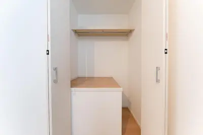 a walk in closet with white walls and white cabinets at STs\u7b39\u585a2\u4e01\u76ee in Tokyo