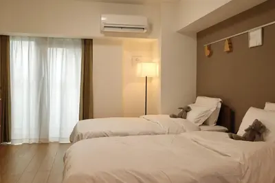 a hotel room with two beds with teddy bears on them at 1001 Deluxe Double Room in Tokyo