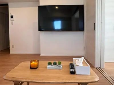 a living room with a wooden table with a tv at 1001 Deluxe Double Room in Tokyo