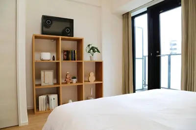 a bedroom with a bed and a tv and a book shelf at 1001 Deluxe Double Room in Tokyo