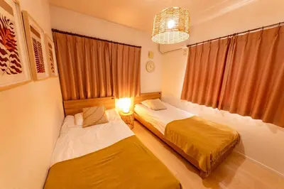 two beds in a room with a window at HOTEL Flag Tokyo in Tokyo