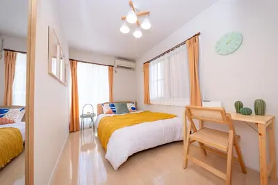 a bedroom with a bed and a desk and a clock at HOTEL Flag Tokyo in Tokyo