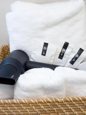 a basket with white towels and a blow dryer at Asakusa 1001 Deluxe Double Room in Tokyo