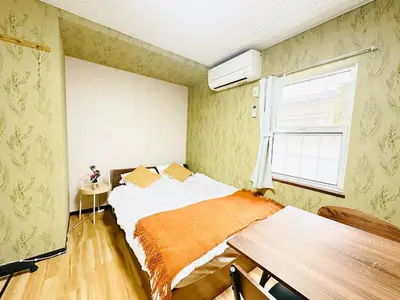 a bedroom with a bed and a table and a window at Liberty Corp 102 - Vacation STAY 18545 in Tokyo