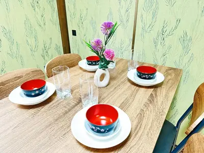 a wooden table with plates and bowls and vases on it at Liberty Corp 102 - Vacation STAY 18545 in Tokyo