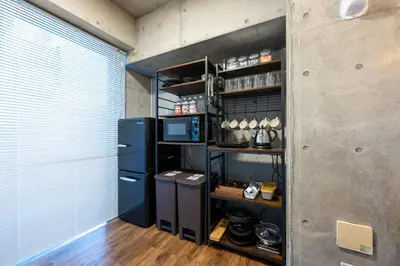 a kitchen with a black refrigerator and a shelf at Stayloop\u5e73\u4e95 in Tokyo