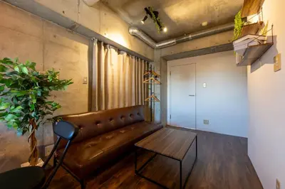 a living room with a leather couch and a table at Stayloop\u5e73\u4e95 in Tokyo