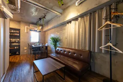 a living room with a leather couch and a table at Stayloop\u5e73\u4e95 in Tokyo