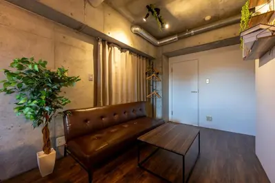 a living room with a leather couch and a table at Stayloop\u5e73\u4e95 in Tokyo