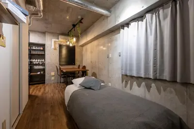 a bedroom with a bed and a table in a room at Stayloop\u5e73\u4e95 in Tokyo