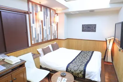 a bedroom with a bed and a desk and a television at HOTEL B-Girl in Tokyo