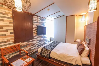 a small room with a bed and a tv at HOTEL B-Girl in Tokyo