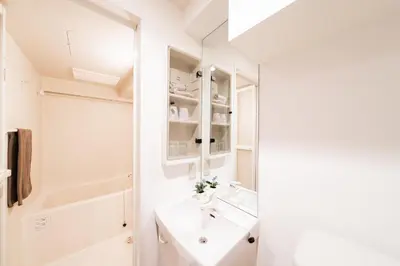 a white bathroom with a sink and a mirror at Shinjuku ,2 minutes from the station in Tokyo