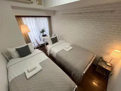 two beds in a room with a brick wall at Shinjuku ,2 minutes from the station in Tokyo