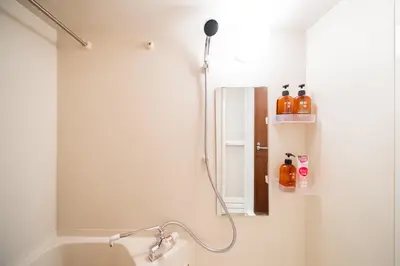 a bathroom with a shower with a mirror and a sink at Shinjuku ,2 minutes from the station in Tokyo