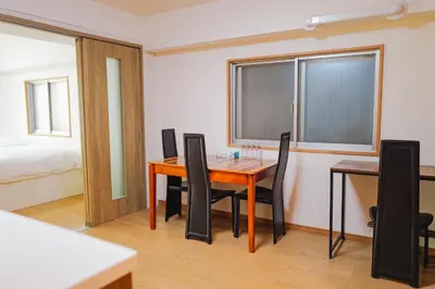 a dining room with a table and chairs and a bed at \u4f4d\u4e8e\u65b0\u6865\u76842\u5367\u5ba4\u516c\u5bd3 in Tokyo