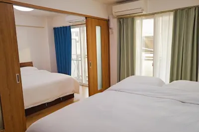 a bedroom with two beds and a window at \u4f4d\u4e8e\u65b0\u6865\u76842\u5367\u5ba4\u516c\u5bd3 in Tokyo