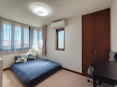 a bedroom with a blue bed and a television at live in Onsen in Tokyo