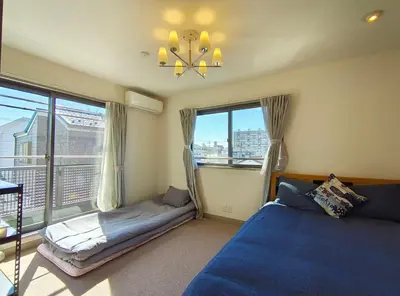 a bedroom with a blue bed and a window at live in Onsen in Tokyo