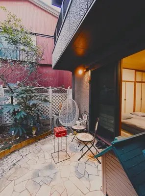 a patio with two chairs and a table on a building at live in Onsen in Tokyo