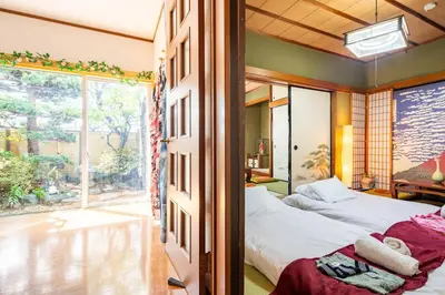 a bedroom with two beds and a large window at \u65b0\u5bbf \u65b0\u5927\u4e45\u4fdd\u99c5108 \u5e73\u7c73\u65e5\u672c\u5ead\u5712\u306e\u5bbf in Tokyo