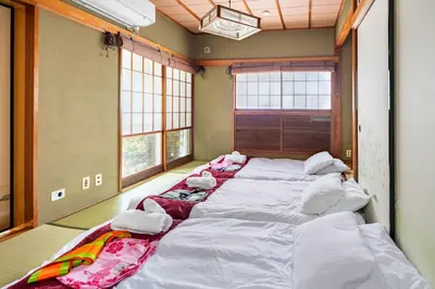 a row of beds in a room with windows at \u65b0\u5bbf \u65b0\u5927\u4e45\u4fdd\u99c5108 \u5e73\u7c73\u65e5\u672c\u5ead\u5712\u306e\u5bbf in Tokyo