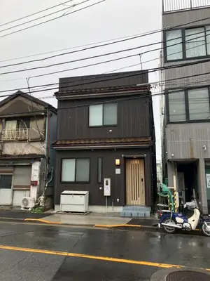 a black house with a motorcycle parked in front of it at \u7537\u6027\u5c02\u7528-Male Only \u30b5\u30af\u30fc\u30ec\u516b\u5e83 in Tokyo