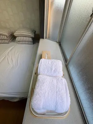 a small bed with two towels on it at Doragon House in Tokyo