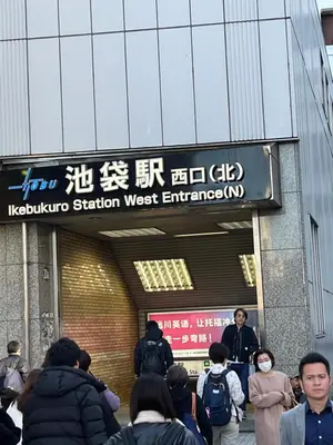 a group of people standing outside of a subway station at Doragon House in Tokyo