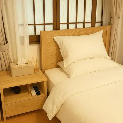 a bed with a wooden headboard and a night stand with a remote control at \u9752\u9ea6\u5bbf\u6cca \u65e9\u7a3b\u7530\u5e97 in Tokyo