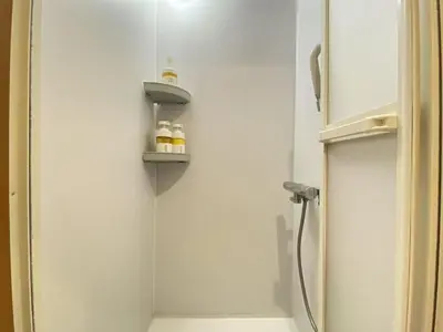 a bathroom with a shower with a shelf in the wall at N5-Guest House in Tokyo ShinKoiwa in Tokyo