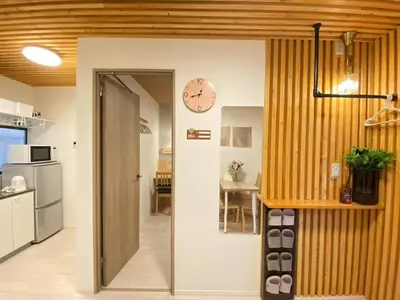 a kitchen with a clock on the wall and a door at N5-Guest House in Tokyo ShinKoiwa in Tokyo