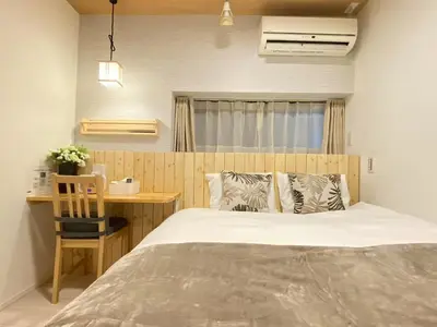 a bedroom with a bed and a table and a desk at N5-Guest House in Tokyo ShinKoiwa in Tokyo