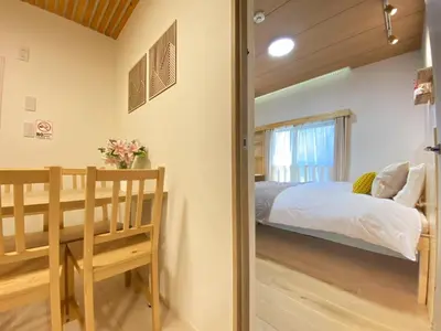a bedroom with a bed and a table and chairs at N5-Guest House in Tokyo ShinKoiwa in Tokyo
