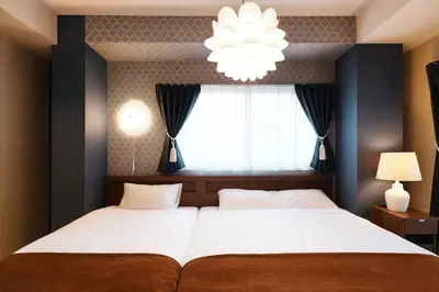 a bedroom with a large bed with a chandelier at Latte Urban Elegance Kinshicho, 5min walk to Station in Tokyo